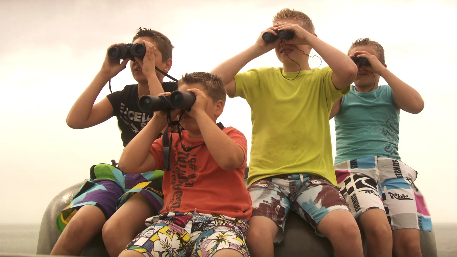 Four boys look through binoculars together in Achter de Toren.