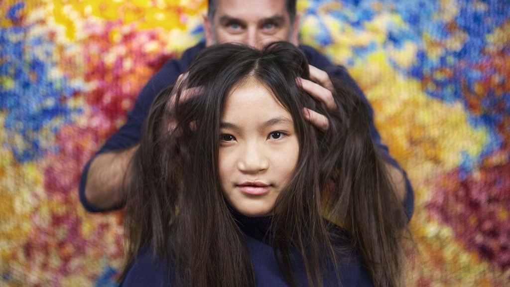 A child having their hair cut by Marko Suds in Talking Heads.